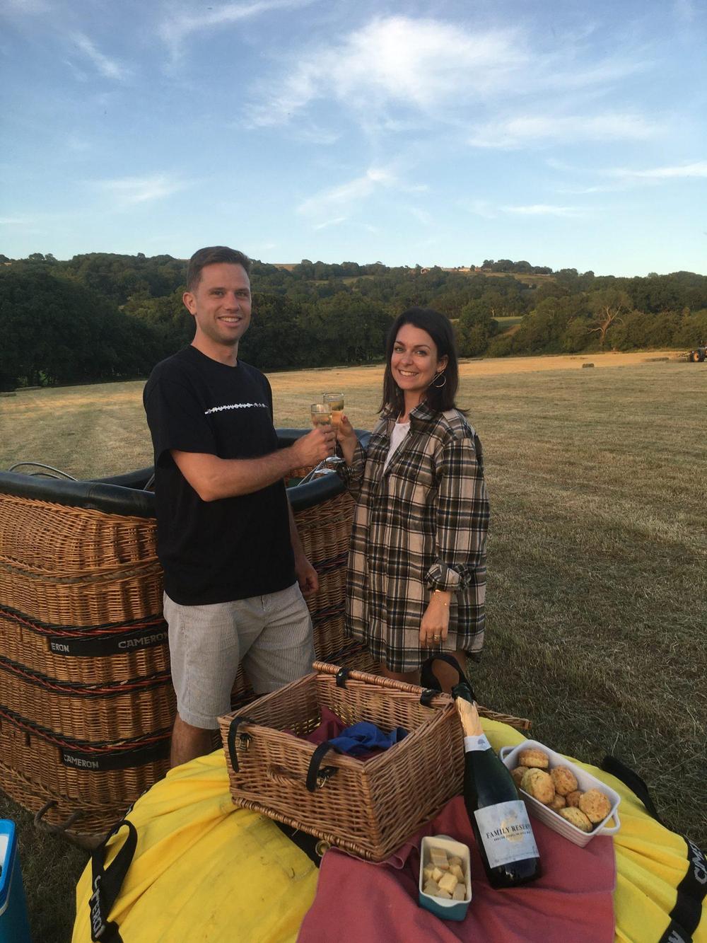 Couple toasting with champagne upon balloon landing