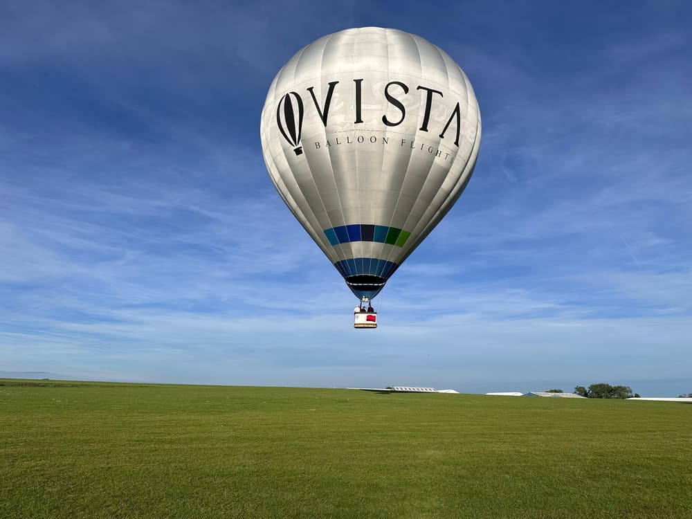 vista balloon hot air balloon in sky above green field