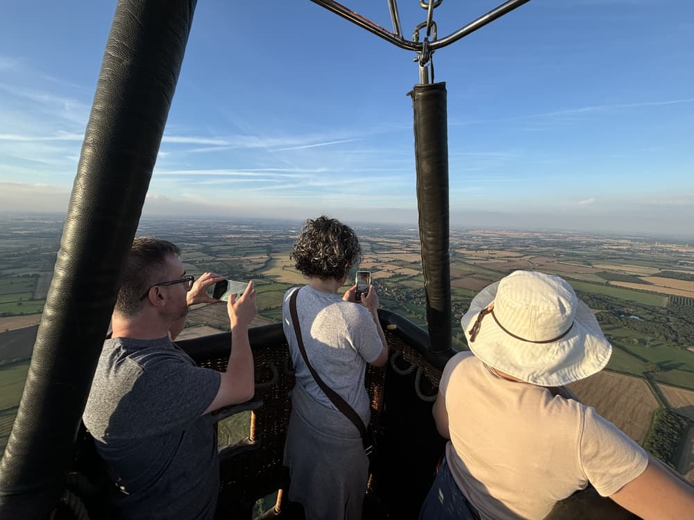 people in a hot air balloon taking photos of the views